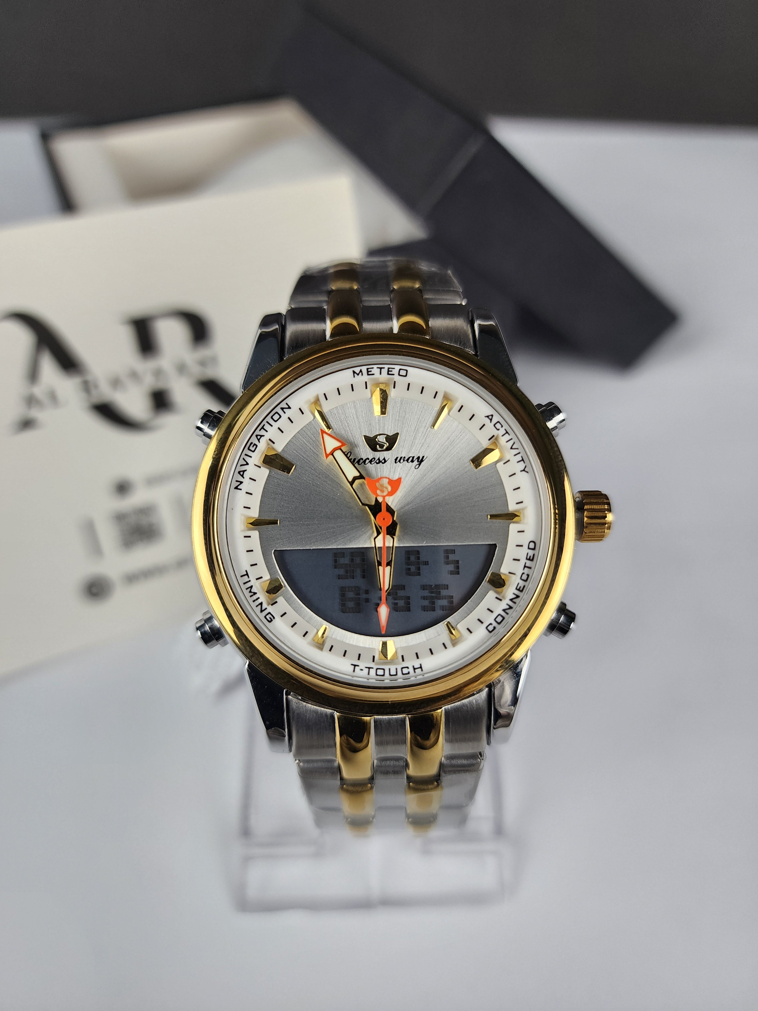 Gold and silver watch with a white face on a blurred background