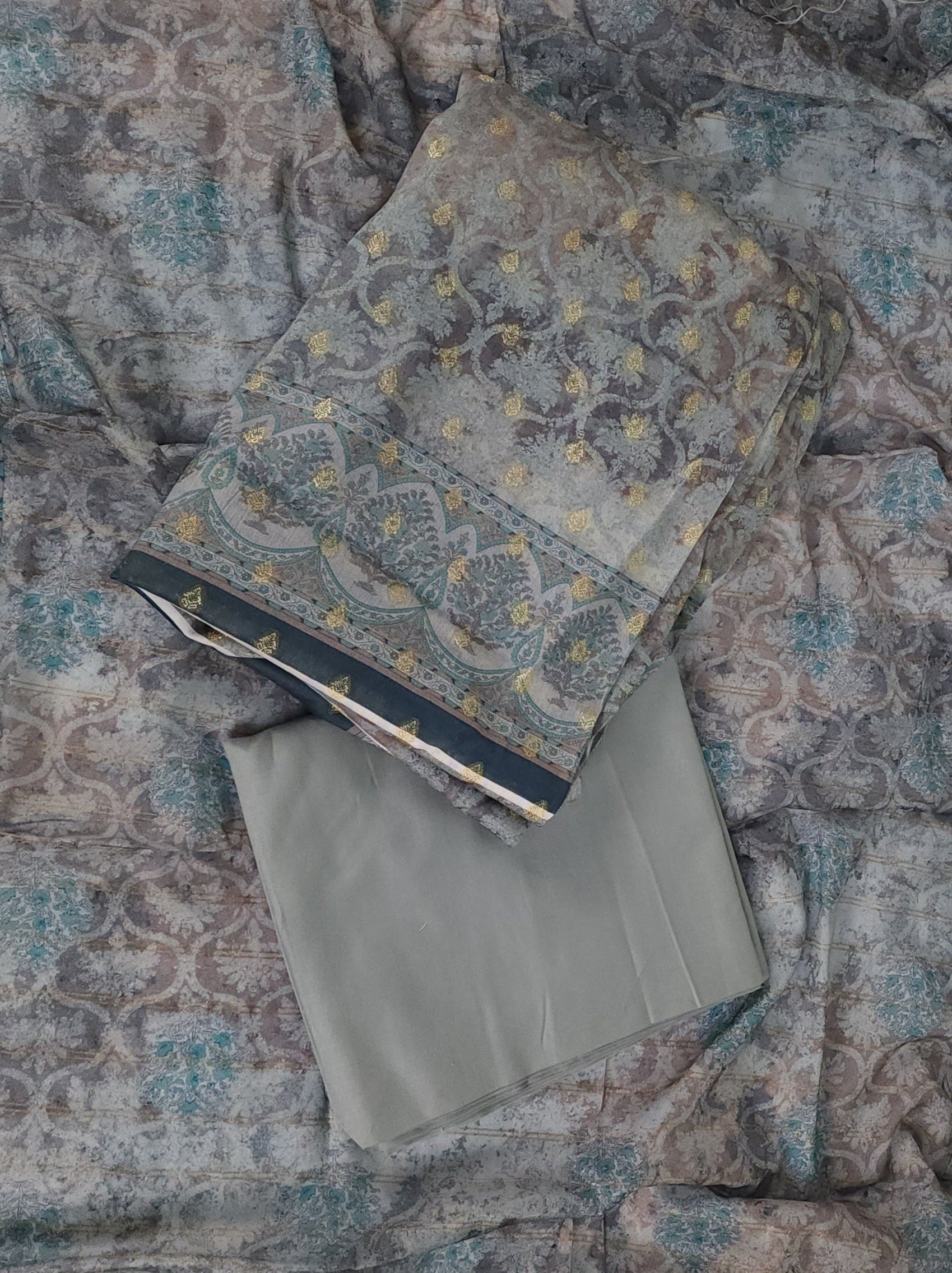 Two patterned books stacked on a textured fabric surface